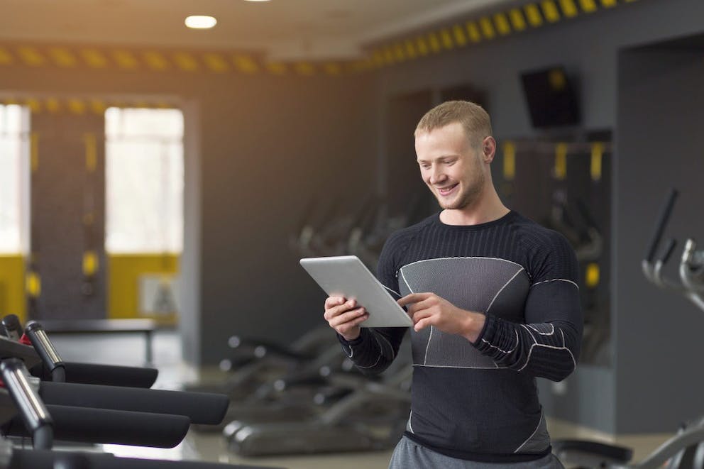 Chàng trai lực lưỡng nhắn tin trên máy tính bảng kỹ thuật số trước khi tập gym | Tại sao bạn nên kết hợp chế độ ăn Keto với việc nhịn ăn gián đoạn | cách nhịn ăn gián đoạn trên keto